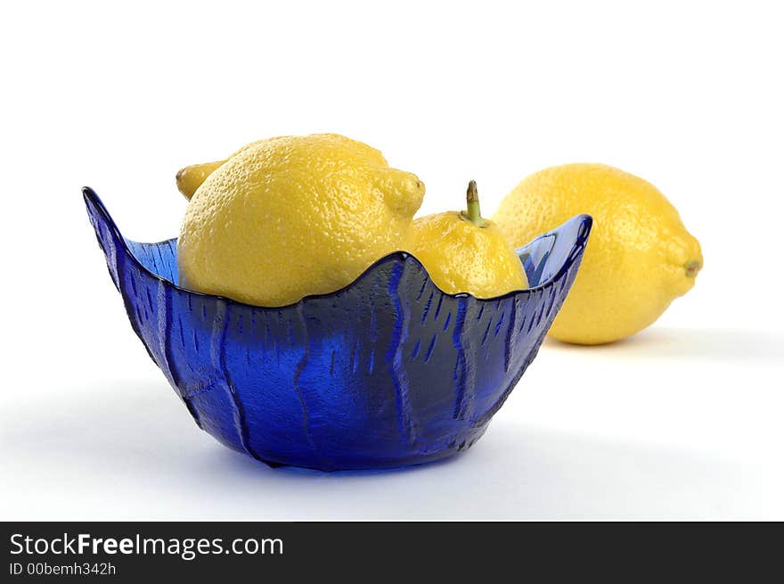 Lemons in a blue glass bowl.