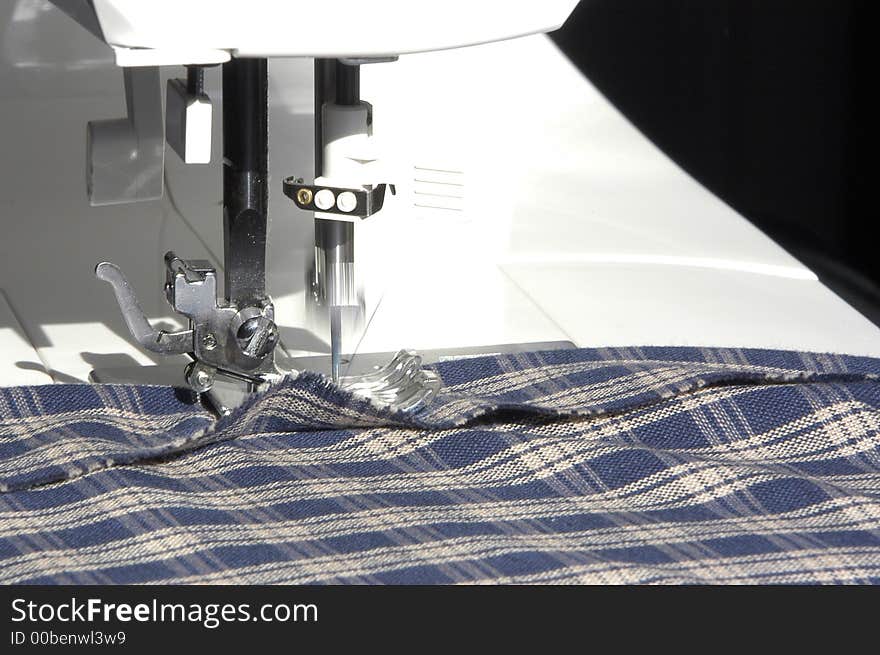 A sewing machine in the process of creating a seam on some cloth. A sewing machine in the process of creating a seam on some cloth.