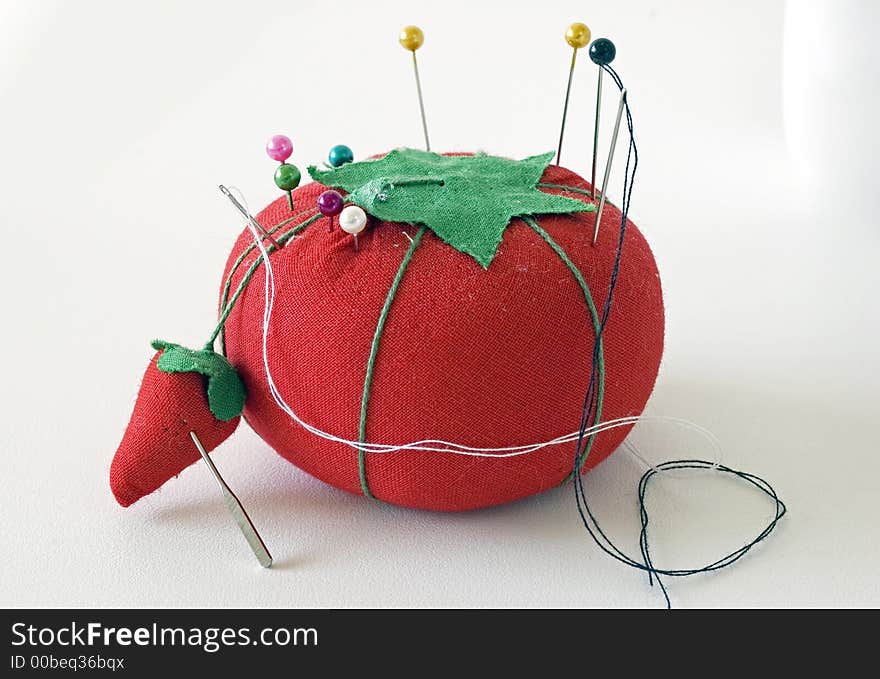 Picture of a pincushion shaped like a tomato and strawberry. Picture of a pincushion shaped like a tomato and strawberry