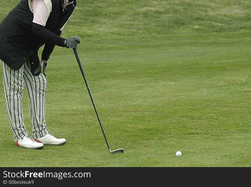 The woman the golfer to prepare for impact of a ball