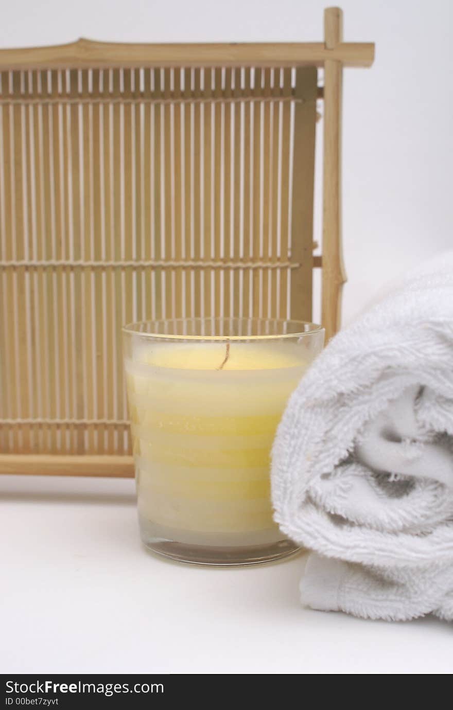 Relaxing scented candle with white towel to show clean and pure bathroom treatment. Relaxing scented candle with white towel to show clean and pure bathroom treatment