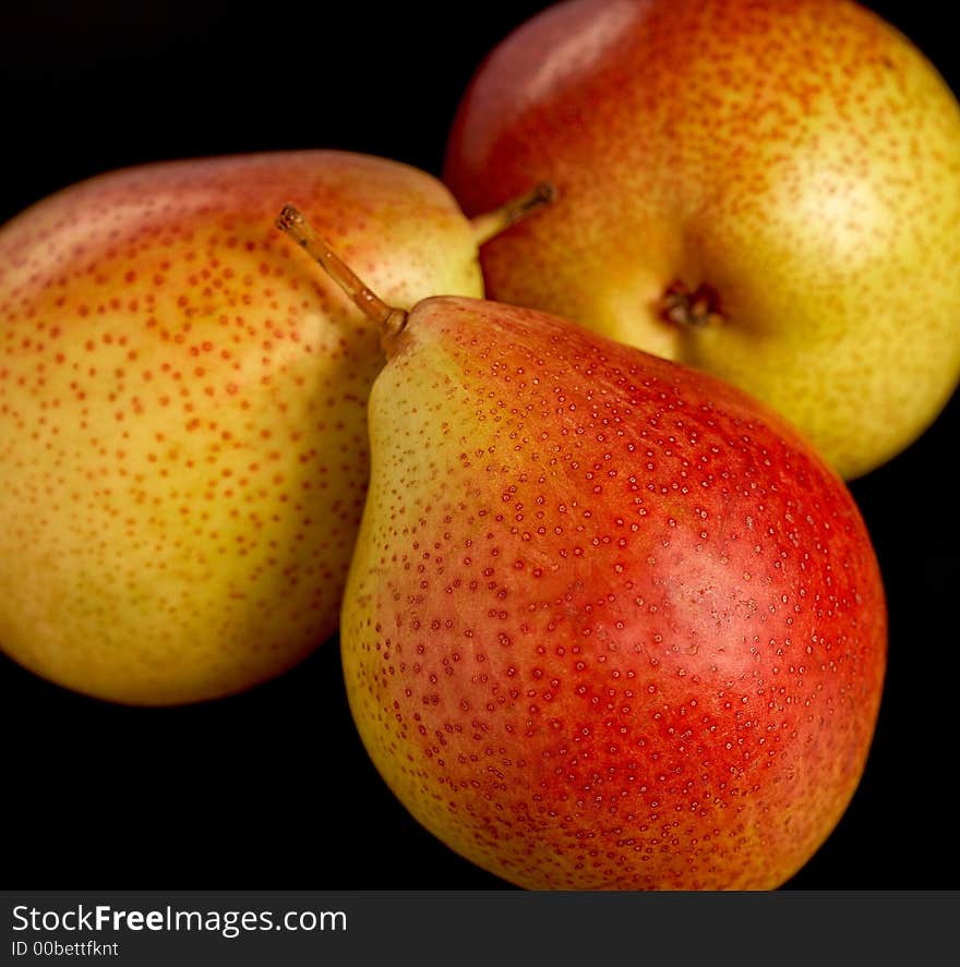 Three pears on black background, close-up