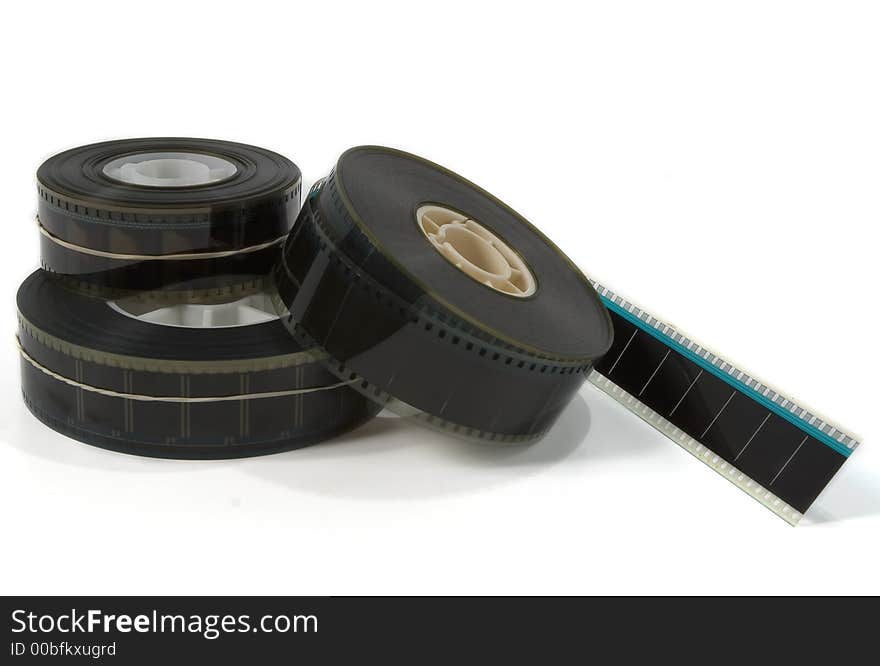 A stack of three 35mm movie film trailers with one unravelling - on white. A stack of three 35mm movie film trailers with one unravelling - on white