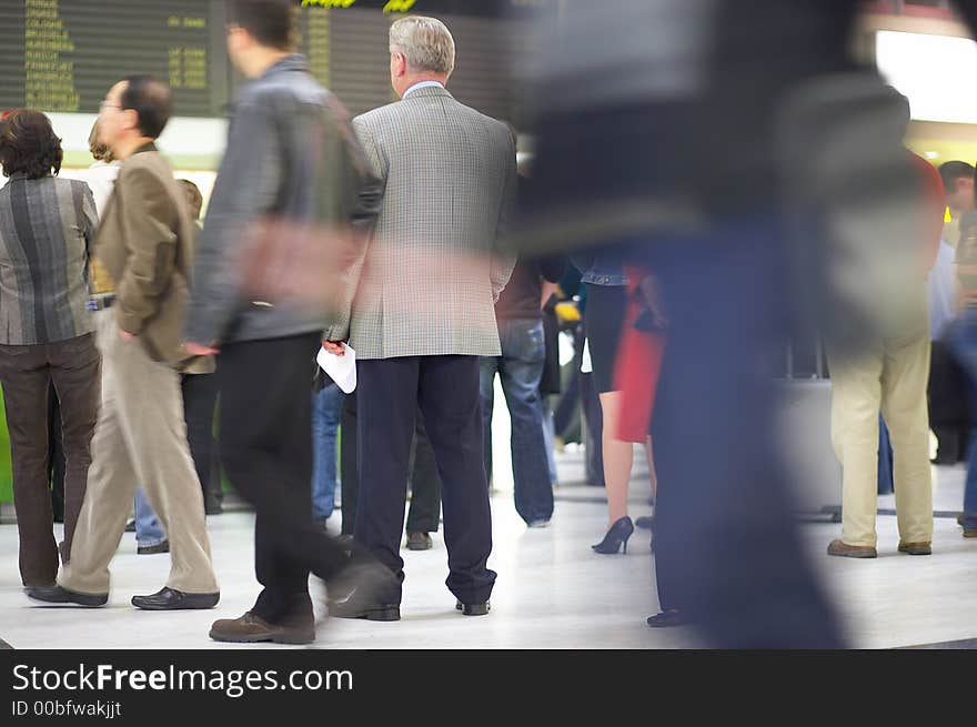 One man is standing sharp and in focus, while the others are moving and blurred. One man is standing sharp and in focus, while the others are moving and blurred