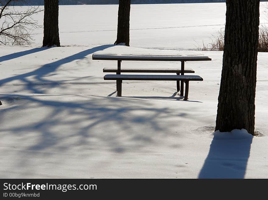 A picnic table sits quietly in the winter snow. A picnic table sits quietly in the winter snow.