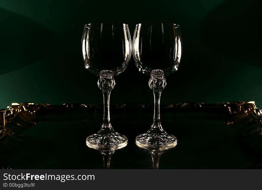 Two wine glasses on a green background, two 300 Watt halogen lamps on both sides. Two wine glasses on a green background, two 300 Watt halogen lamps on both sides