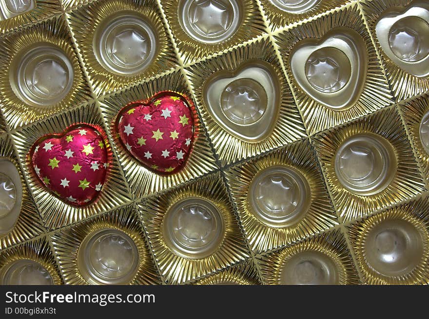 Box with two chocolate candies in shape of heart, a valentine's day gift. Copyspace provided.