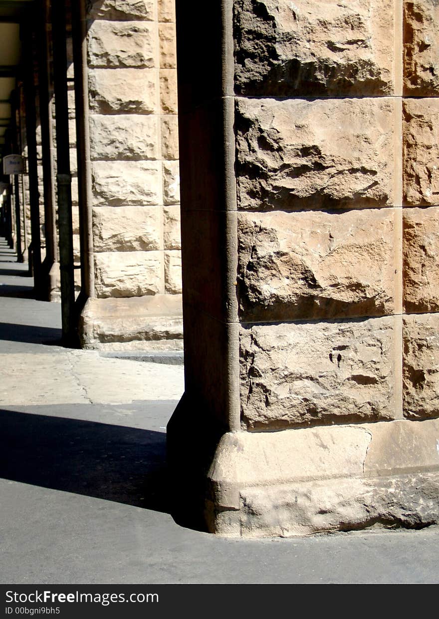 A row of weathered stone pillars in the bright sun