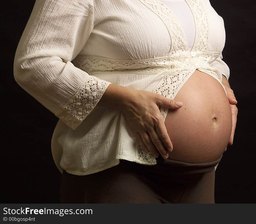 A very pregnant Mom shows her tummy for portrait session. A very pregnant Mom shows her tummy for portrait session.