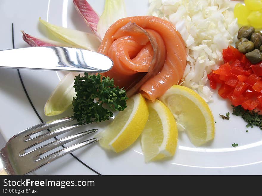 Slices of fresh kipper on the plate with lemon and spices