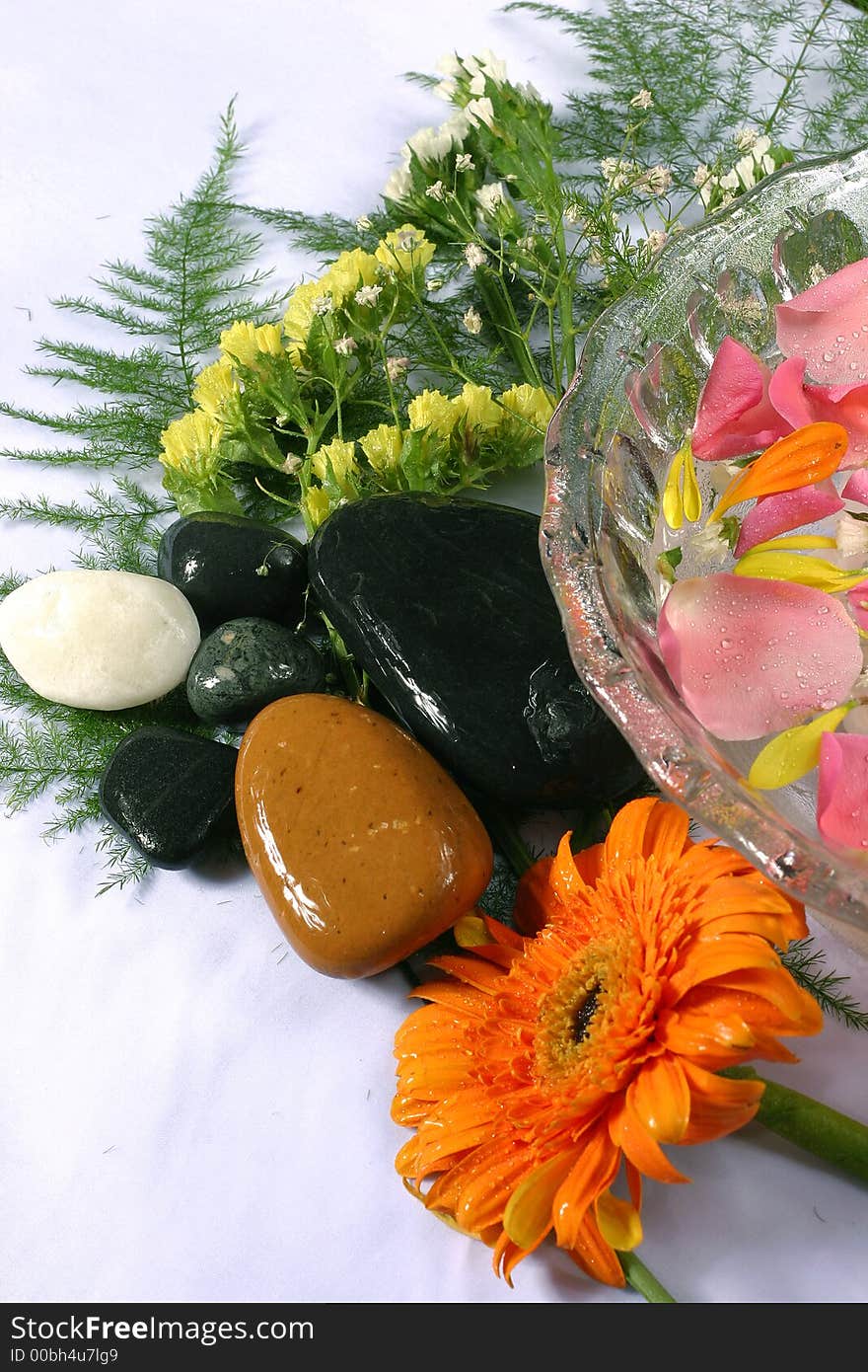 Transparency bowl with nice and fresh pink rose petal and natural pebbles on the flower background. Suitable for spa and relaxation setting. Transparency bowl with nice and fresh pink rose petal and natural pebbles on the flower background. Suitable for spa and relaxation setting.