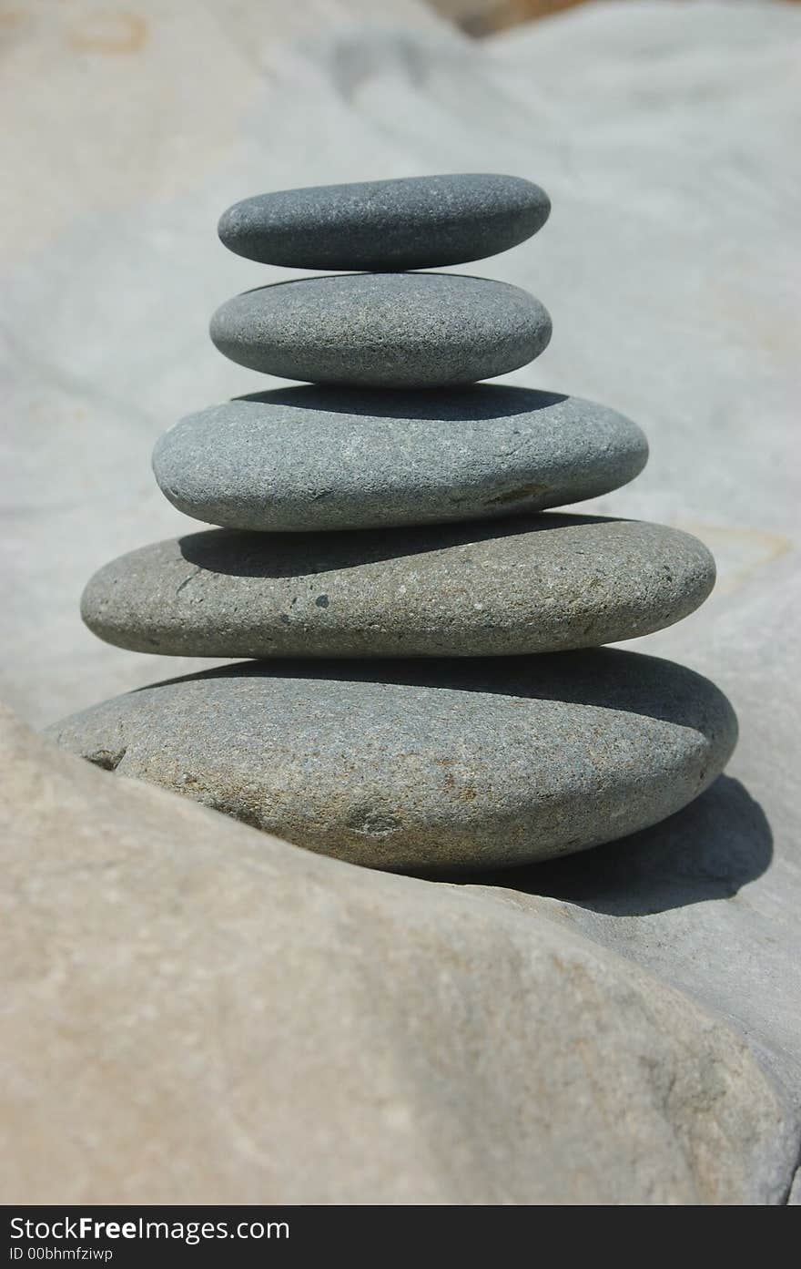 Smooth stones stacked up on a smooth rock. Smooth stones stacked up on a smooth rock