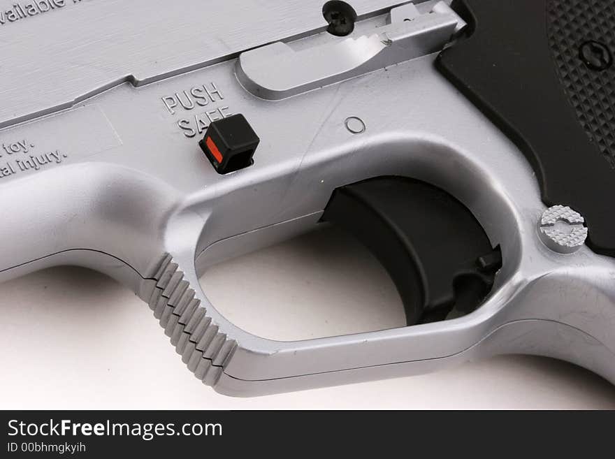 Close-up of a toy gun trigger and safety button