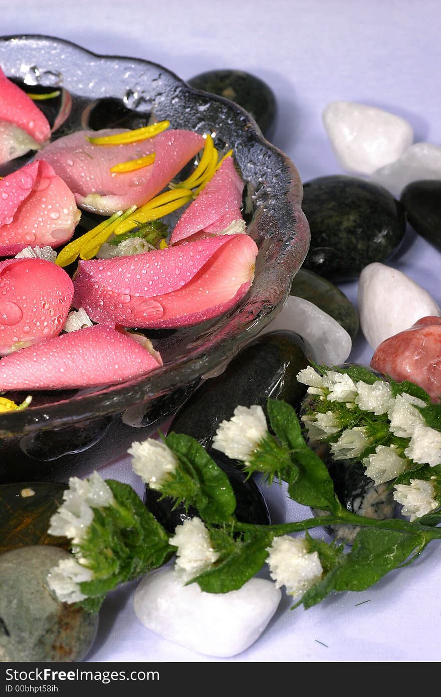 Transparency bowl with nice and fresh pink rose petal and natural pebbles on the flower background. Suitable for spa and relaxation setting. Transparency bowl with nice and fresh pink rose petal and natural pebbles on the flower background. Suitable for spa and relaxation setting.