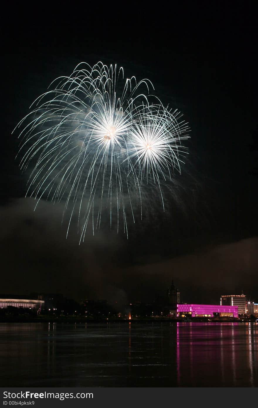 Fireworks in Linz (Austria) at the Danube river with beautiful reflections. On the right side the Brucknerhaus (orchestra house) on the left the Lentos (Museum) with its illuminated walls. Fireworks in Linz (Austria) at the Danube river with beautiful reflections. On the right side the Brucknerhaus (orchestra house) on the left the Lentos (Museum) with its illuminated walls.