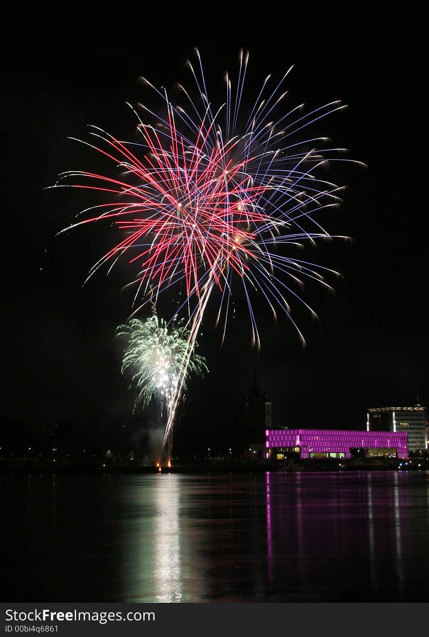 Fireworks in Linz (Austria) at the Danube river with beautiful reflections. On the right side the Brucknerhaus (orchestra house) on the left the Lentos (Museum) with its illuminated walls. Fireworks in Linz (Austria) at the Danube river with beautiful reflections. On the right side the Brucknerhaus (orchestra house) on the left the Lentos (Museum) with its illuminated walls.