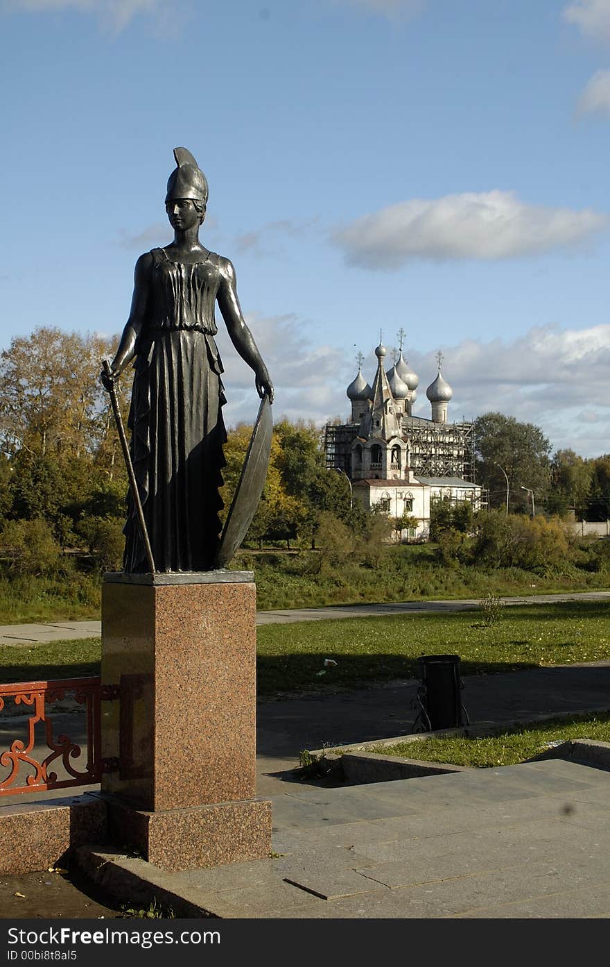 Women`s statue and chucrh on the river. Vologda, Russia.