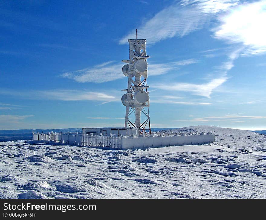 A frozen observatory on the top of the mountain in winter time