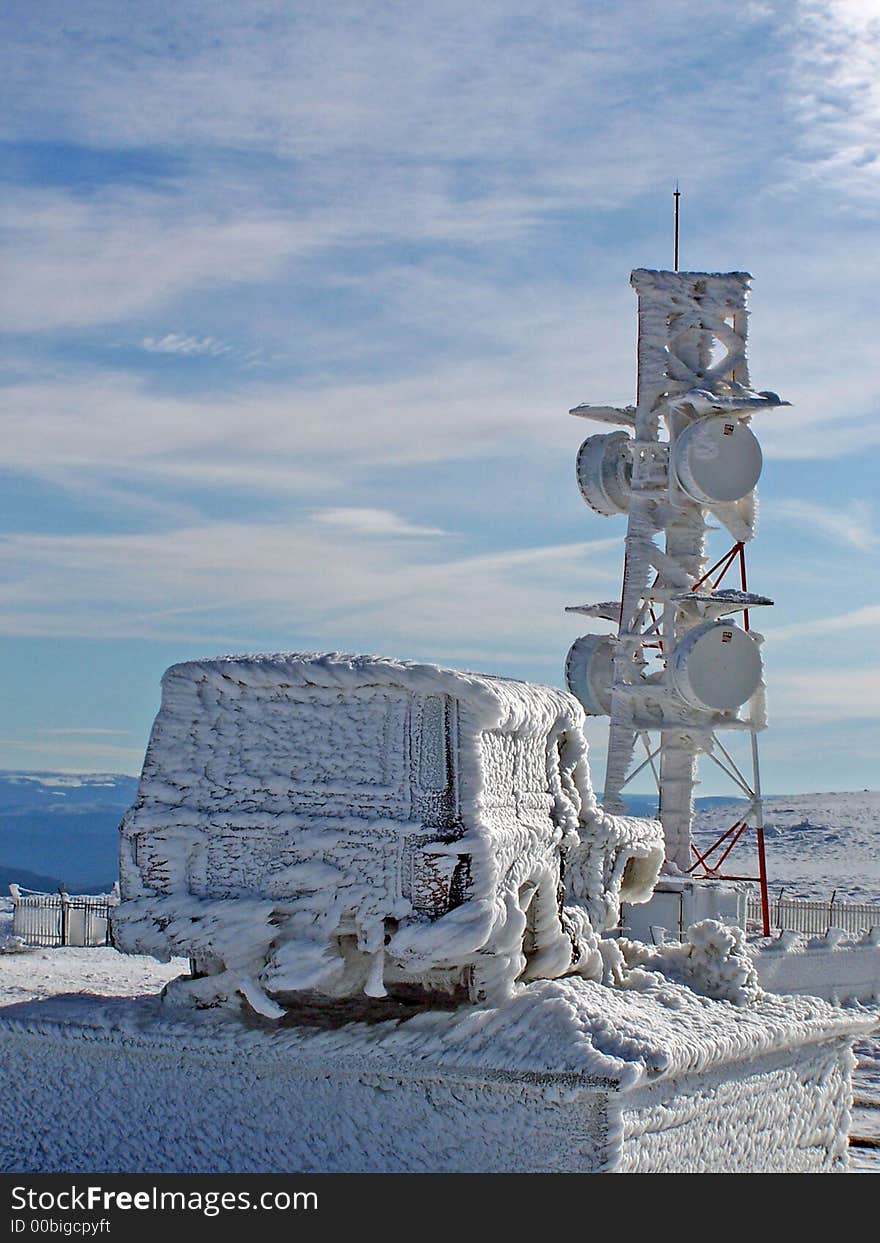 A meteo observatory and a car covered with frozen snow, looking like scupltures. A meteo observatory and a car covered with frozen snow, looking like scupltures