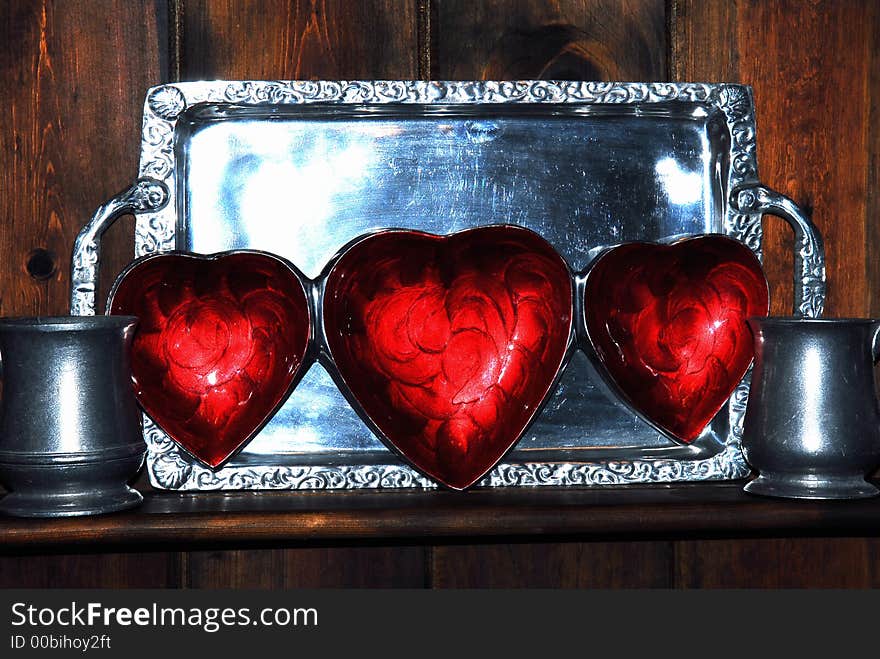 Three red Hearts tray displayed for Valentines against a pewter tray and mugs. Three red Hearts tray displayed for Valentines against a pewter tray and mugs.