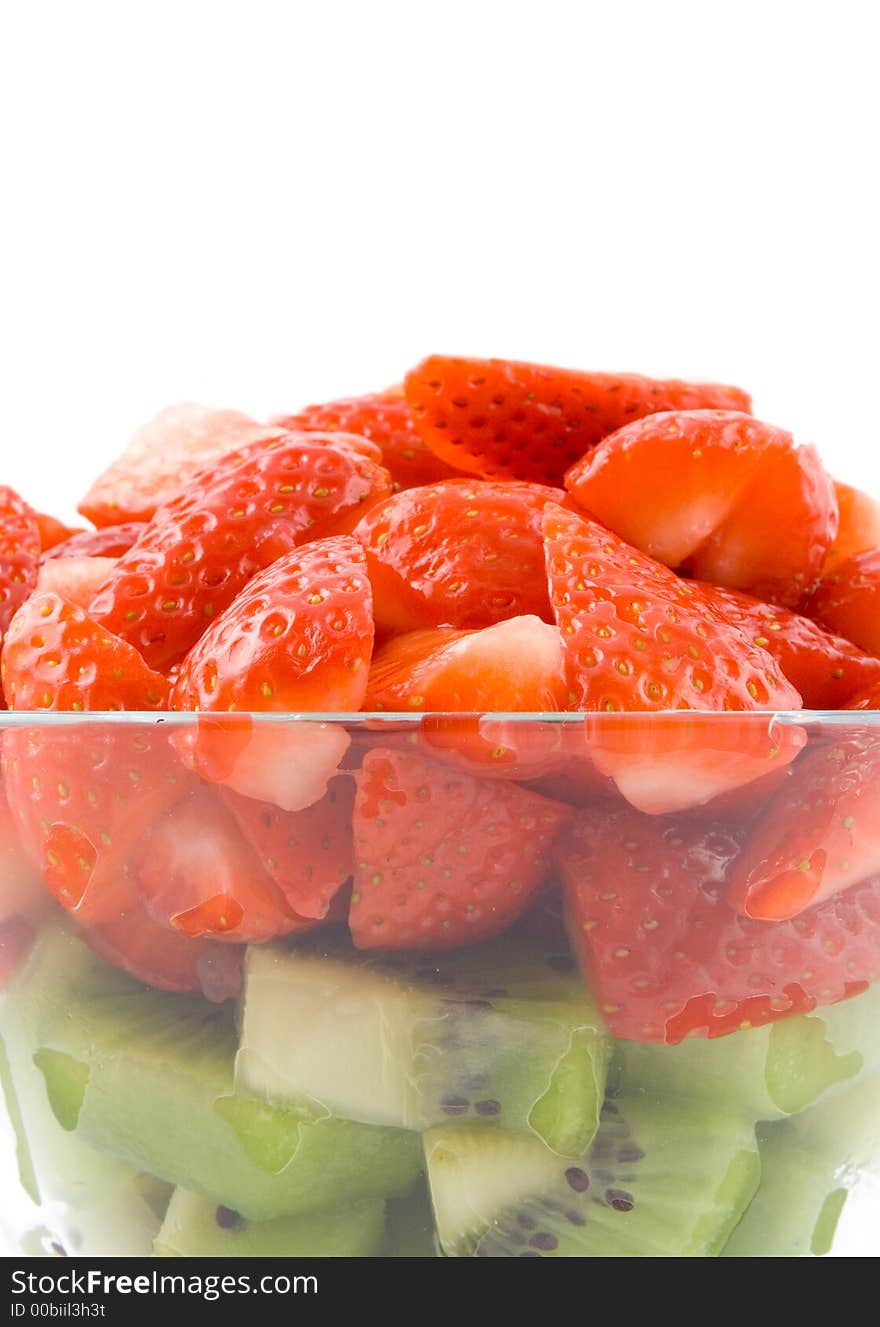 Red and green, strawberry with kiwi in transparent bowl on white background. Isolated