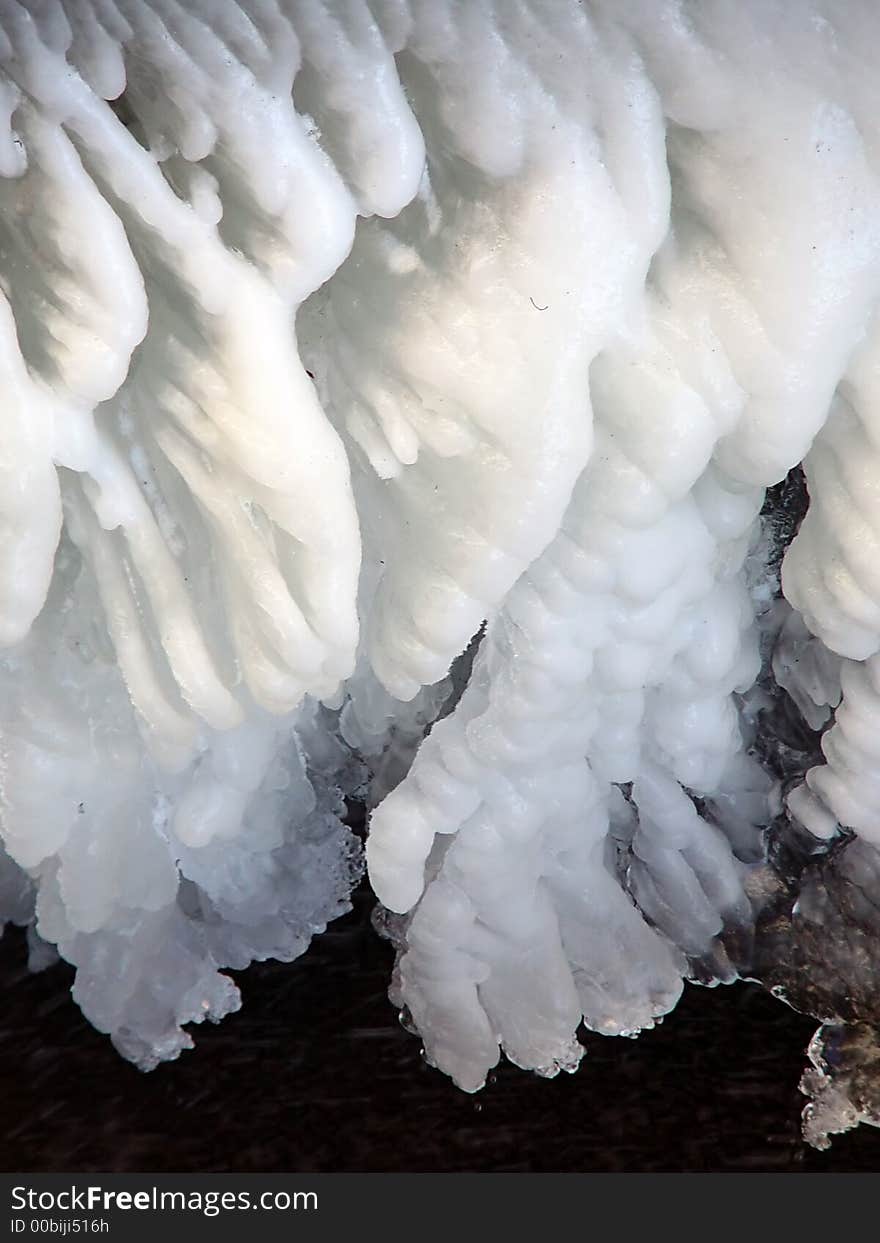 Large section of snow and ice above  flowing water. Large section of snow and ice above  flowing water