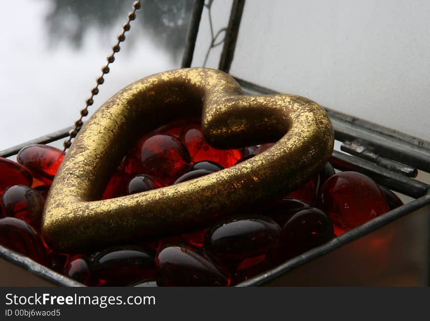 Beautiful heart in a box with red glass beads and a hint of winter in the back ground. Beautiful heart in a box with red glass beads and a hint of winter in the back ground