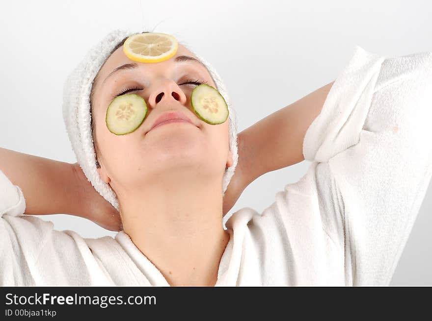 Attractive woman with fruits on face on white background. Attractive woman with fruits on face on white background