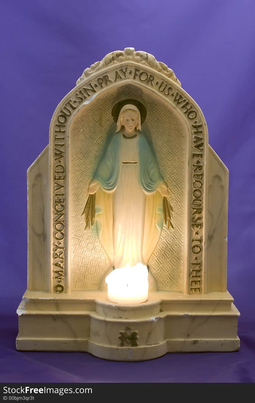 Antique statuette of the Virgin Mary with lit candle. Antique statuette of the Virgin Mary with lit candle.