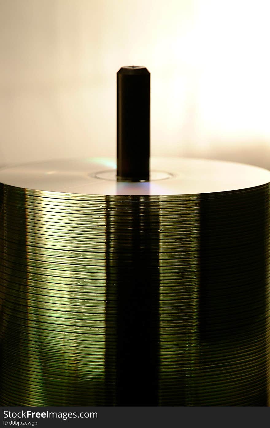 A back lit spindle of translucent cds. A back lit spindle of translucent cds.