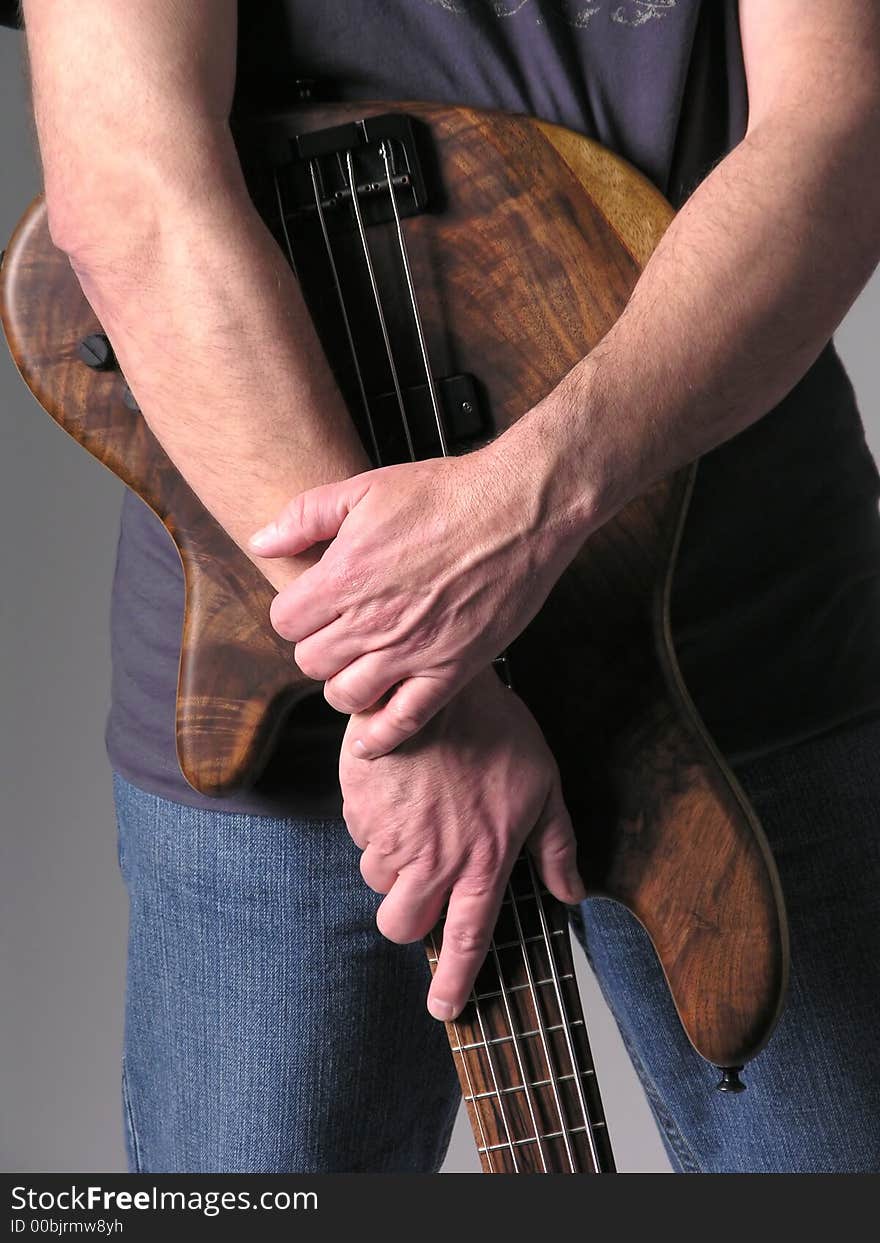 Bass guitar musician playing wood bass guitar. Bass guitar musician playing wood bass guitar