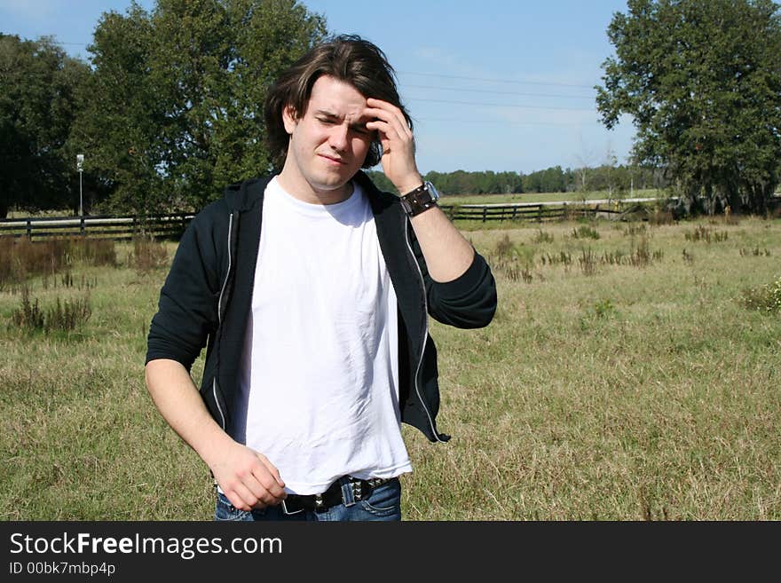 Photo of a young man outside in a field. Photo of a young man outside in a field