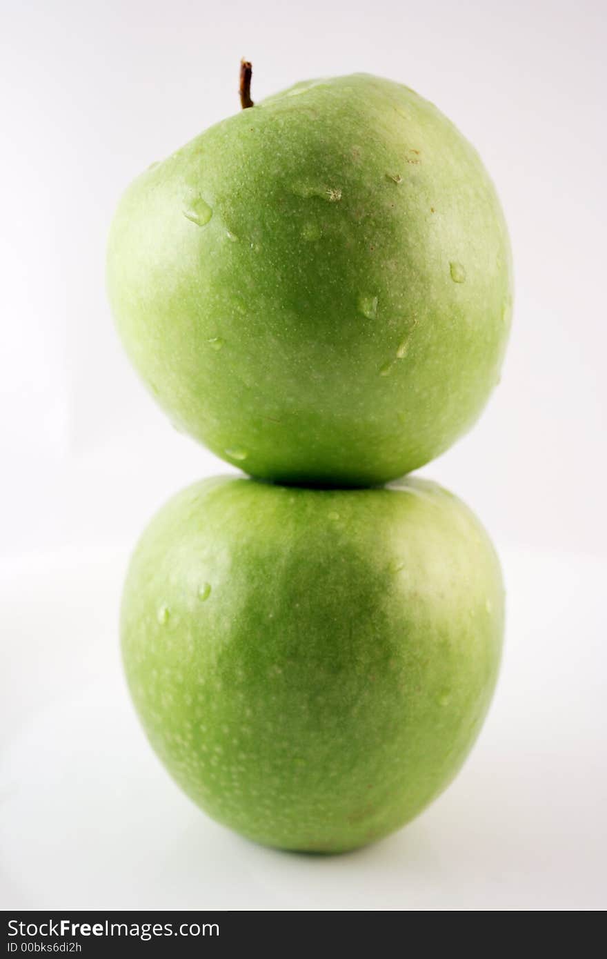 Green apple on top of another green apple. Green apple on top of another green apple