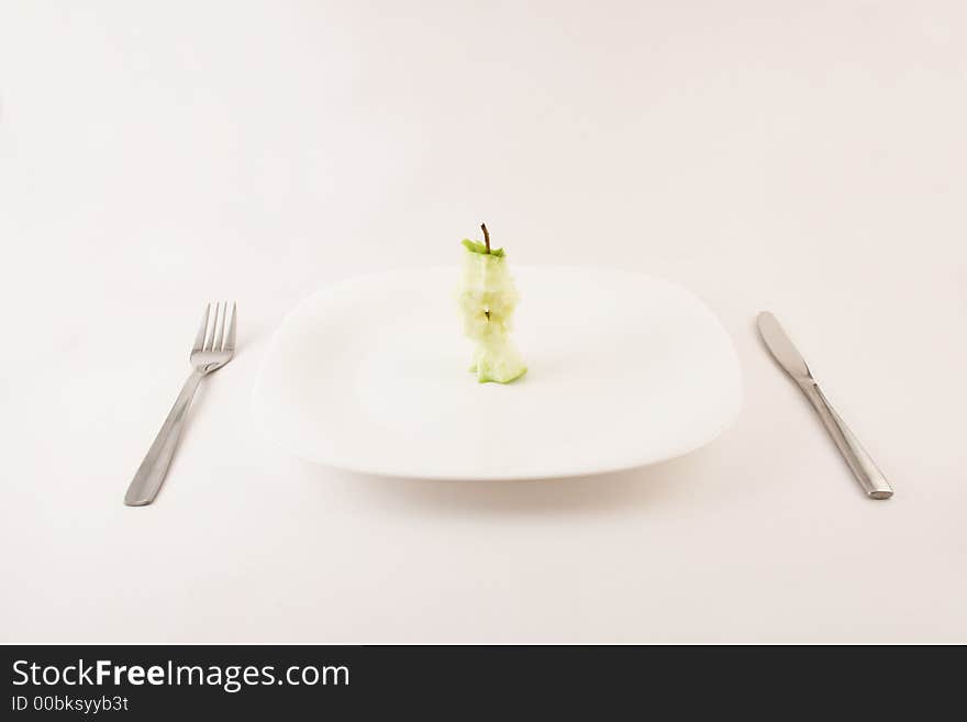 Apple stump on a plate with fork and knife