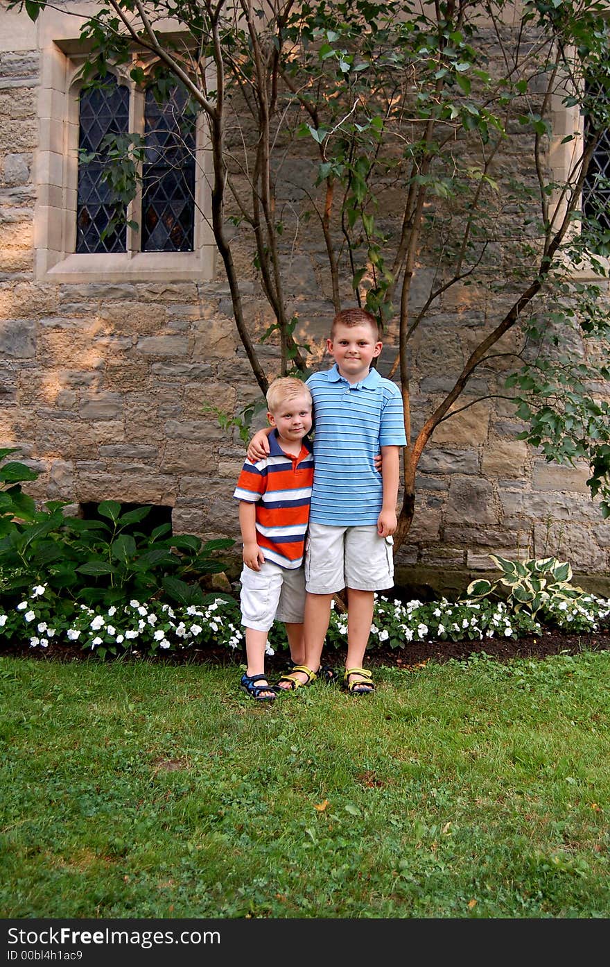 Two brothers standing together in front of a church. Two brothers standing together in front of a church.