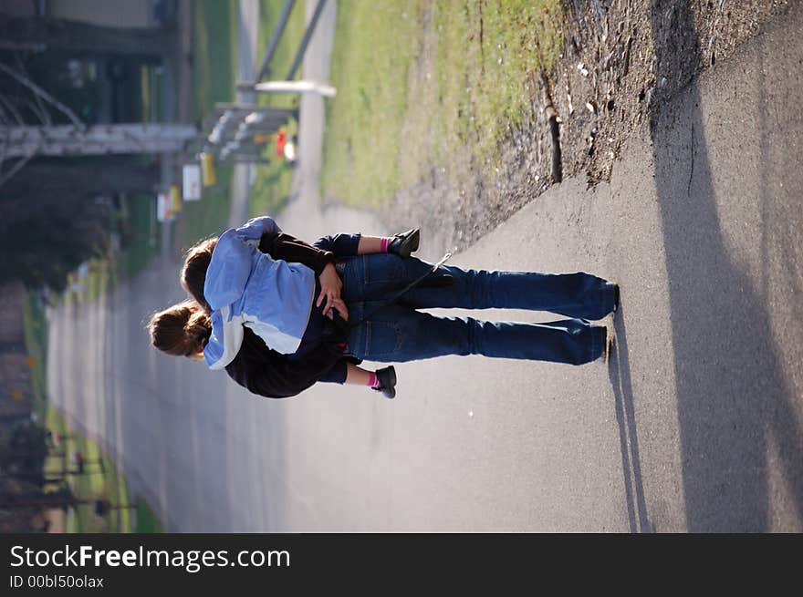 Woman giving piggyback ride to young girl on a rural country road. Woman giving piggyback ride to young girl on a rural country road.