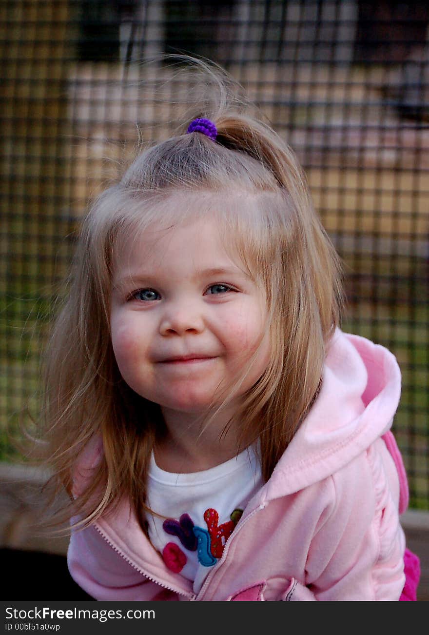 Two year old girl in pink smiling straight into the camera. Two year old girl in pink smiling straight into the camera.