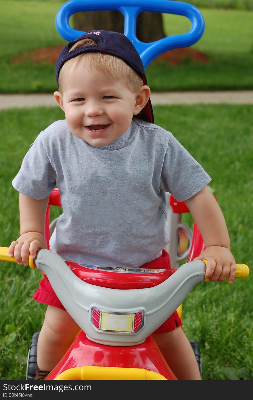 One year old boy riding on a toy and laughing. One year old boy riding on a toy and laughing.