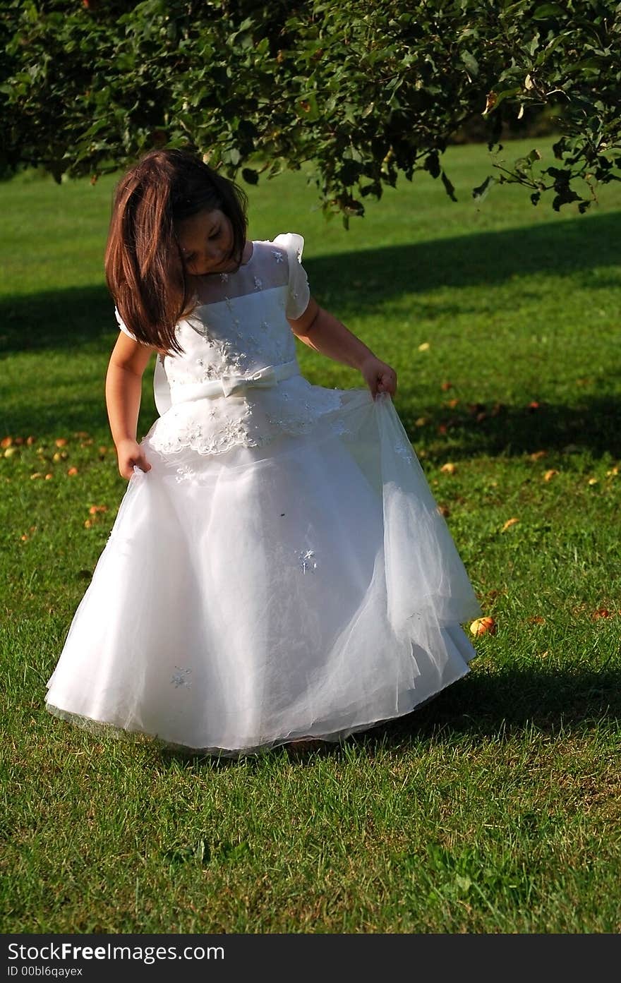 Four year old flower girl in white dress dancing outside. Four year old flower girl in white dress dancing outside.