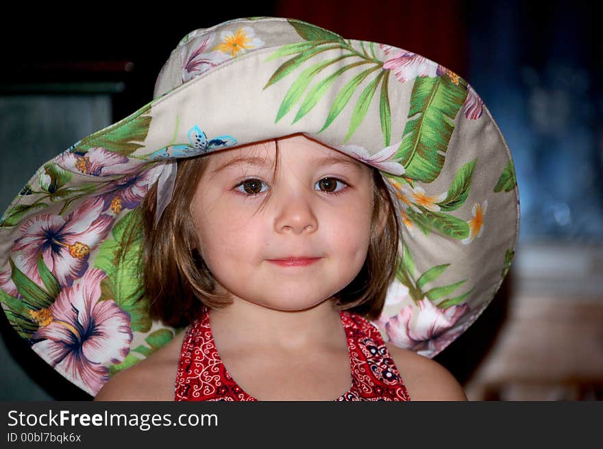 Four year old girl in a large floral sunhat. Four year old girl in a large floral sunhat.