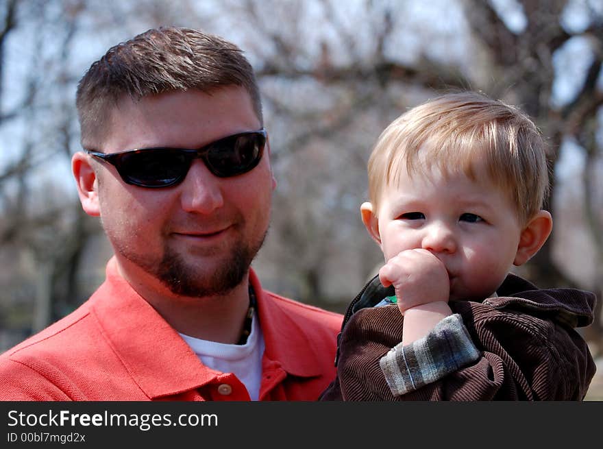 Man in his late twenties holding a one year old boy who is sucking his thumb. Man in his late twenties holding a one year old boy who is sucking his thumb.