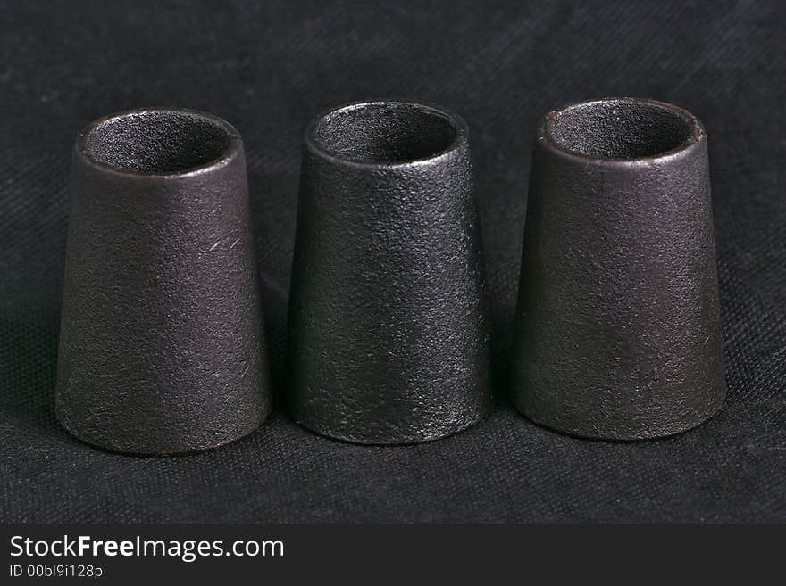 Three candlesticks from metal. macro, black background. Three candlesticks from metal. macro, black background.