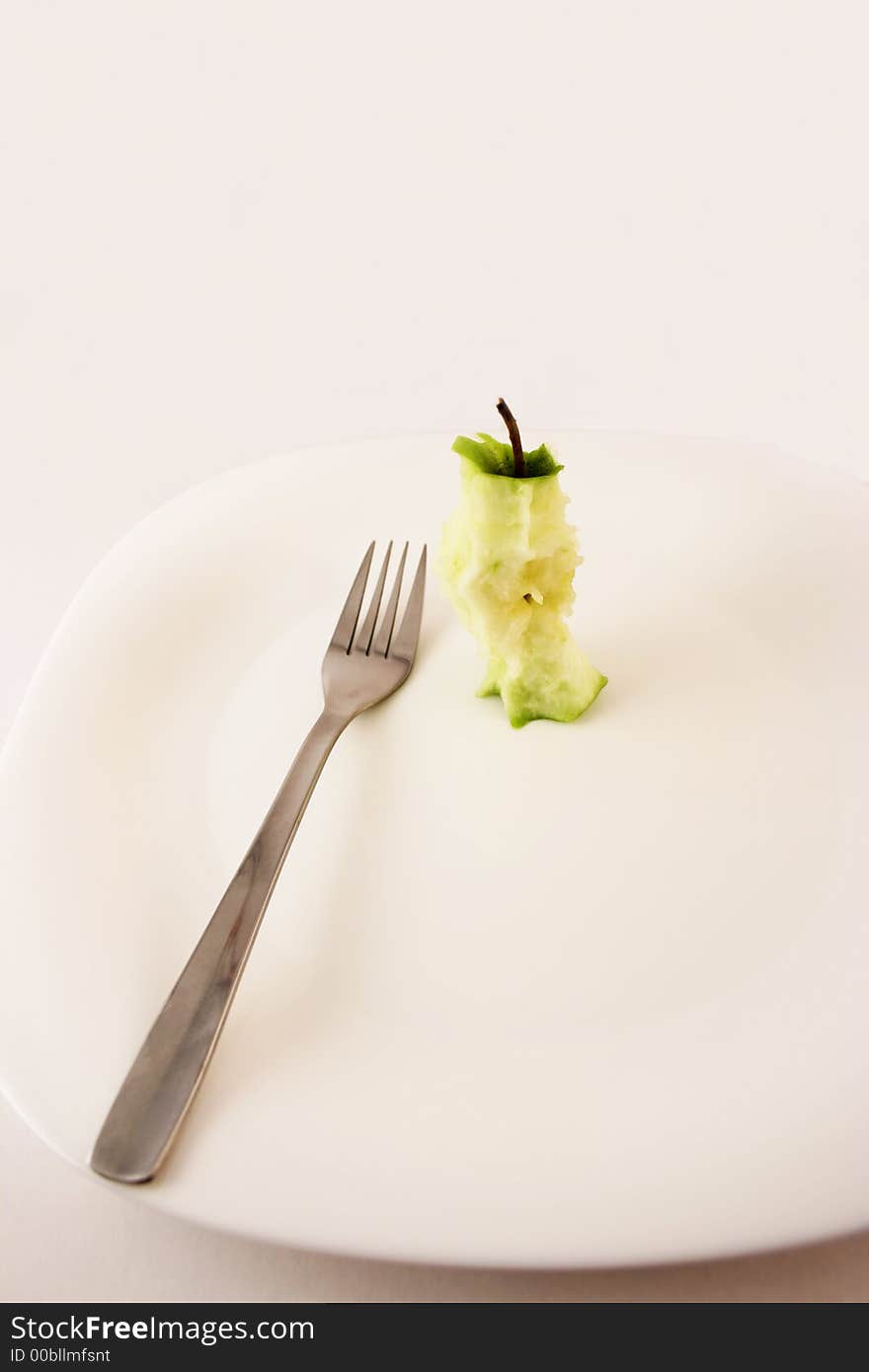 Stump apple with fork set on a white plate