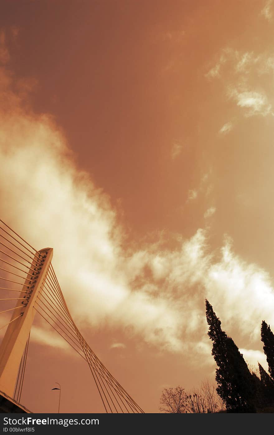 Detail of modern bridge with sky and clouds in background. Trees on the right side. Sepia toning. Detail of modern bridge with sky and clouds in background. Trees on the right side. Sepia toning.