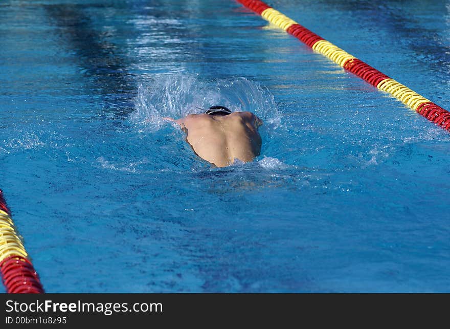 Young man swimming the butterfly event at a swim meet. Young man swimming the butterfly event at a swim meet.