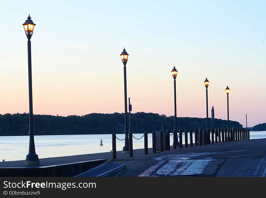 A boat launch with lamp posts at twilight time near sunset. Taken along the Niagara River in Lewiston. Canada is seen in the distance across the river. A boat launch with lamp posts at twilight time near sunset. Taken along the Niagara River in Lewiston. Canada is seen in the distance across the river