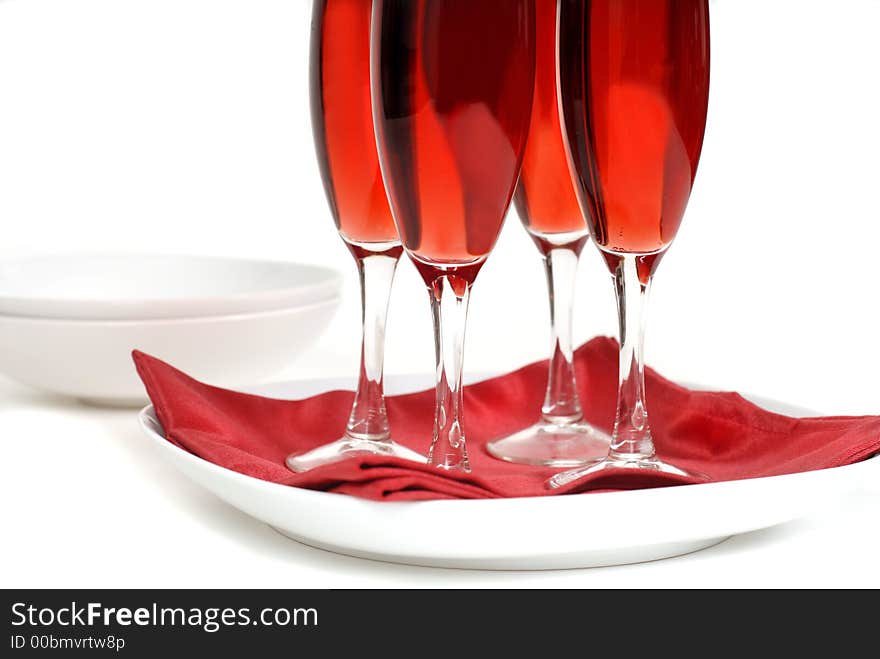 Four glasses of rose champagne on a red napkin isolated on white