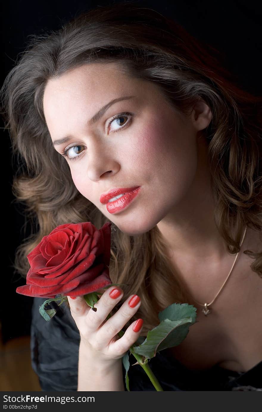 Lady with red rose portrait against black background. Lady with red rose portrait against black background.