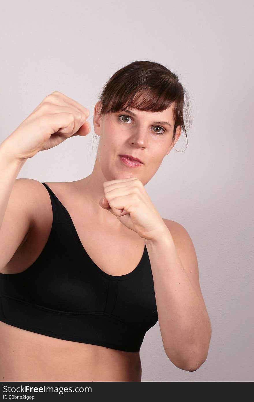 A young white woman is showing her fists in a boxer pose. A young white woman is showing her fists in a boxer pose.