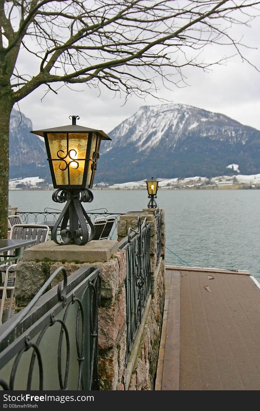 A couple of lit lamps on a lake-front baluster. A couple of lit lamps on a lake-front baluster